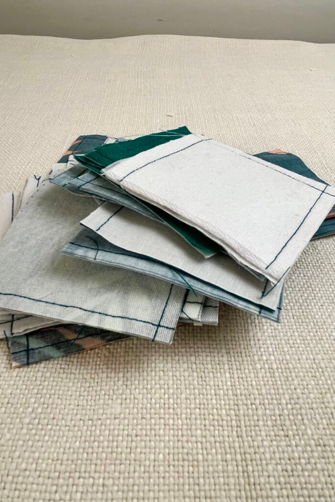 Cut fabric pieces for advent calendar pockets in 3x3 inch squares, ready to turn.  