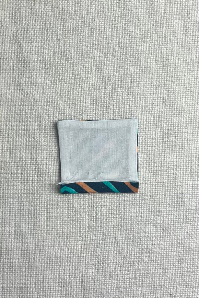 Pressed fabric pocket with folded raw edges.