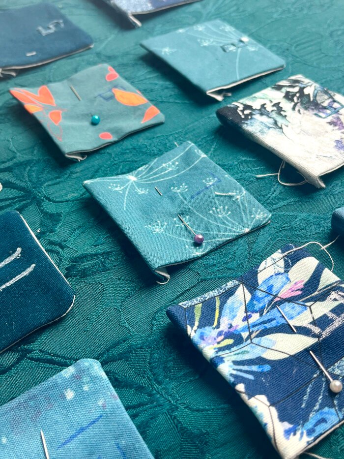 Pressed fabric pockets with folded raw edges, arranged ready for numbering and layout planning.