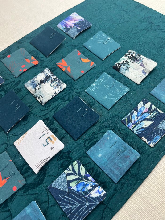 Pockets sewn onto the backing of the advent calendar, ready for tacking the top corners to the backing.