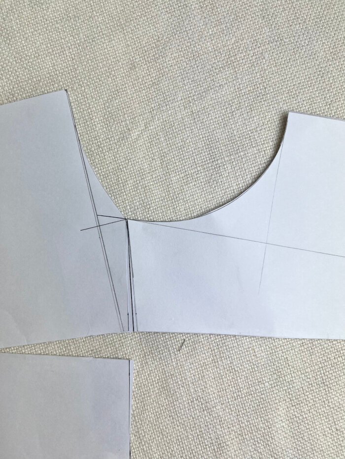 Matching the front and back neckline at the shoulder to assess curve continuity and correct sharp angles.