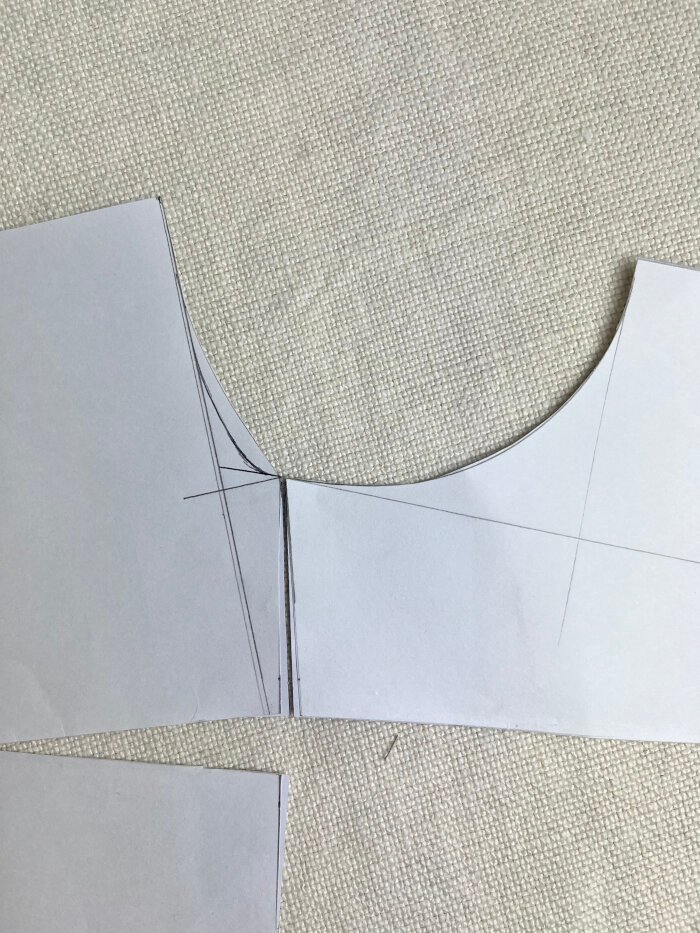 Matching the front and back neckline at the shoulder to assess curve continuity and correct sharp angles.