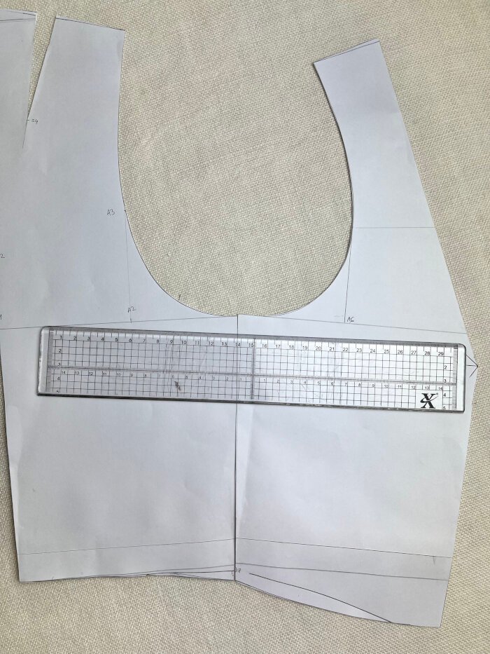 Matching the front and back armhole at the shoulder to assess curve continuity and correct sharp angles.