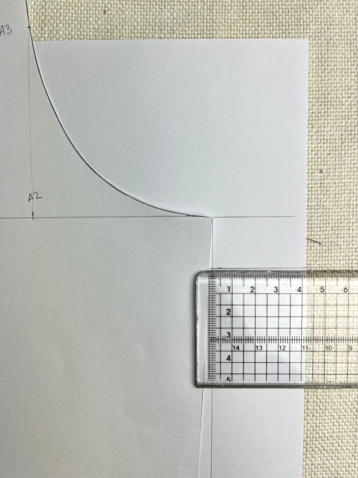 Measuring bust ease on the bodice block by extending the bust line and checking width differences at the armhole.