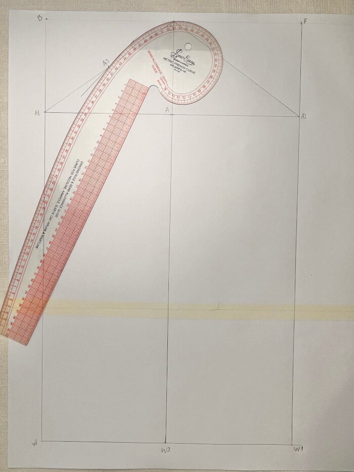 Drawing the back armhole curve of the sleeve block with a French curve.