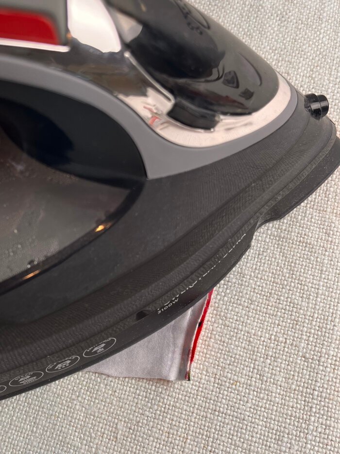 Pressing fabric scrap seams flat after sewing and then pressing the seam allowances to one side for a smooth coaster surface