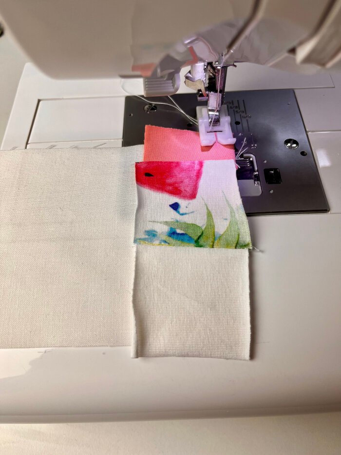 Sewing fabric scrap strips onto backing fabric for a quilted coaster