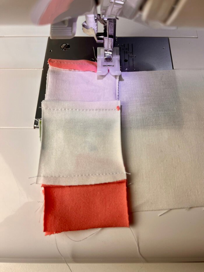 Sewing fabric scrap strips onto backing fabric for a quilted coaster