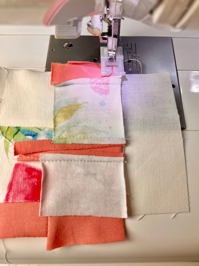 Sewing fabric scrap strips onto backing fabric for a quilted coaster