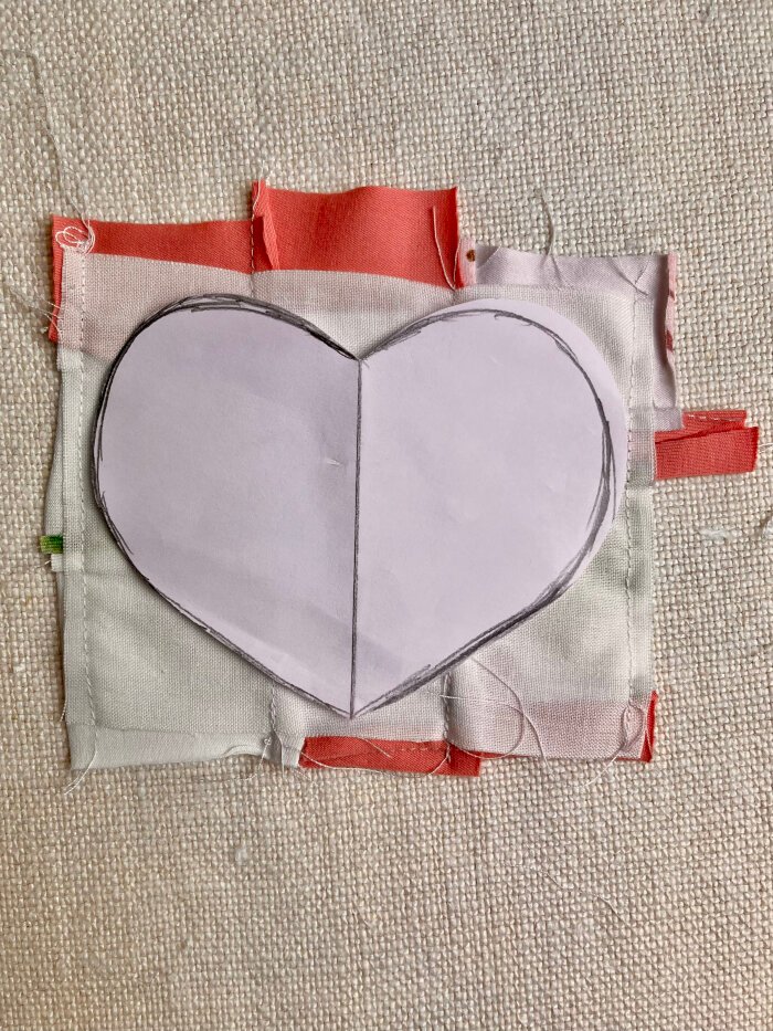 Tracing a heart shaped coaster template onto the quilted fabric using a removable fabric marker
