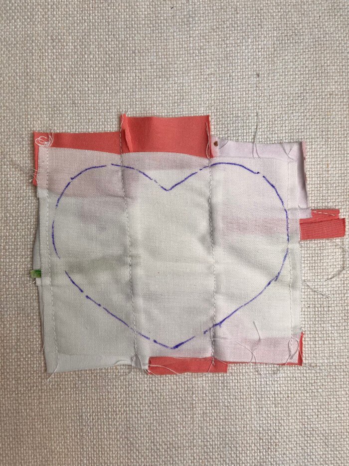 Tracing a heart shaped coaster template onto the quilted fabric using a removable fabric marker