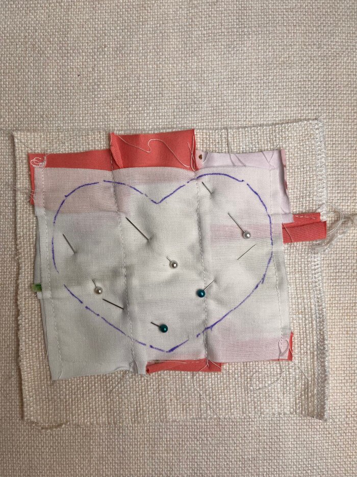 Pinning the quilted fabric layers together before sewing the heart shaped coaster
