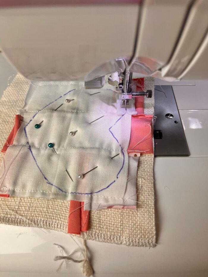 Sewing the layered fabric pieces together along the traced heart shape to form the coaster

