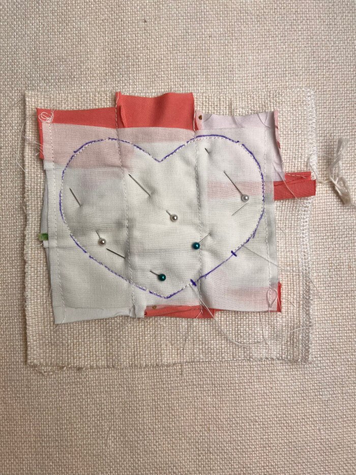 Sewing the layered fabric pieces together along the traced heart shape to form the coaster