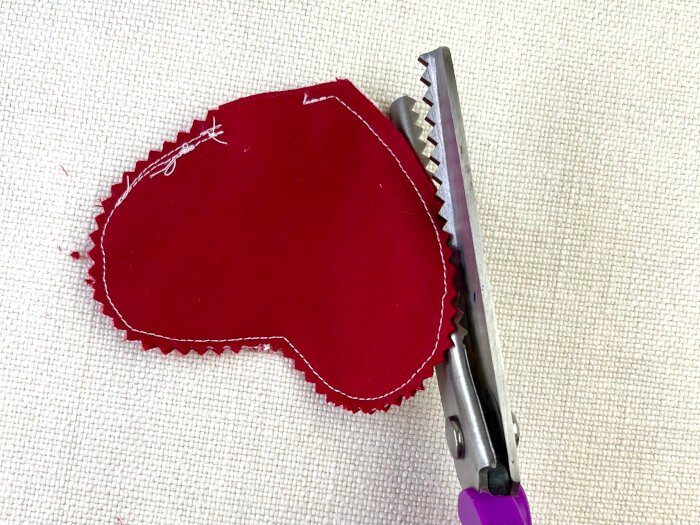 Trimming the seams allowance on the fabric brooch with pinking shears