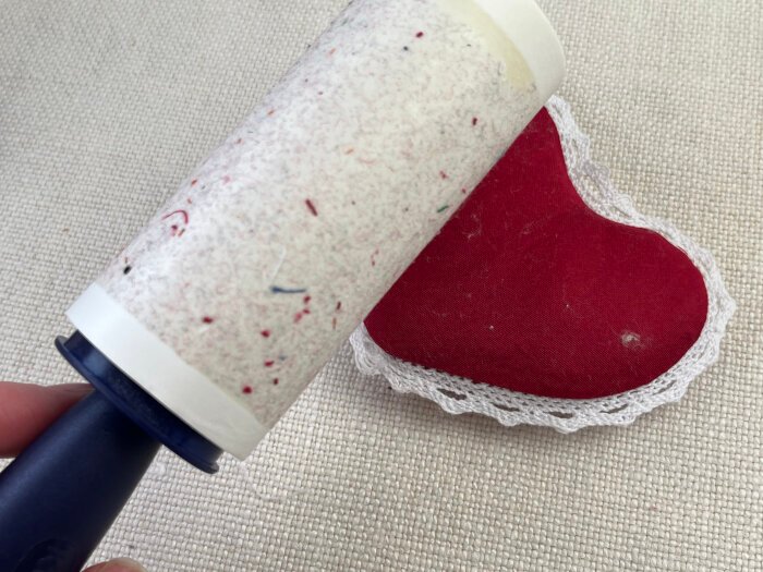 Removing fluff from the DIY brooch  with lint remover.