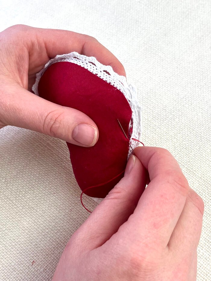 Slip stitching the opening closed on a heart shaped fabric brooch by hand