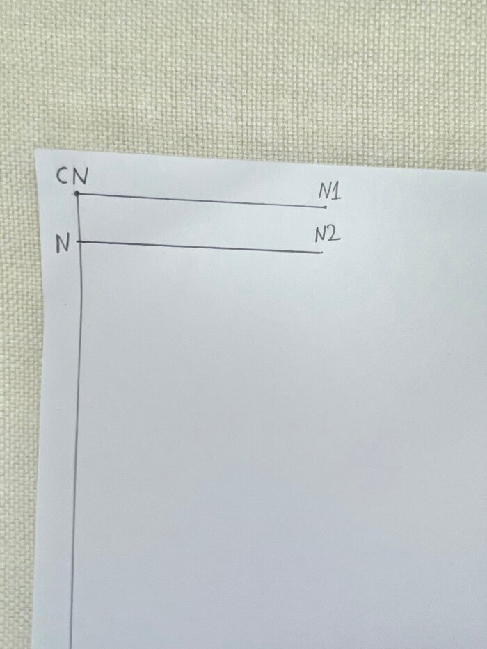 Marking neckline width and depth on a basic T-shirt bodice block using neck circumference measurement.