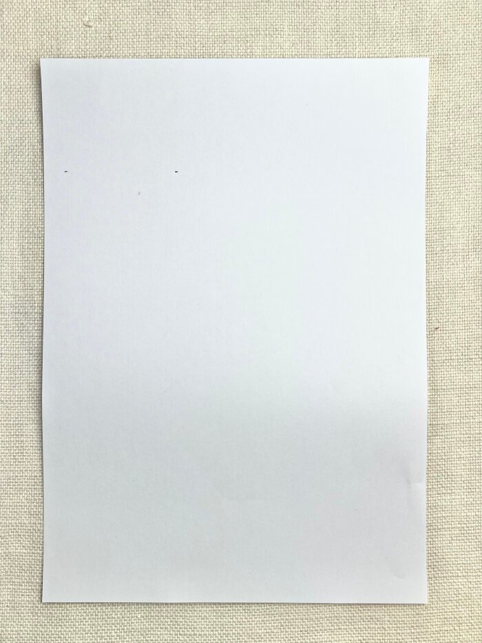 Marking neckline depth on paper to draft a baby drool bib pattern