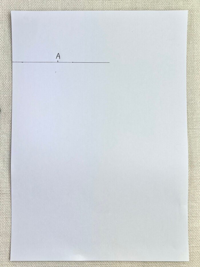 Marking back neckline width on paper to draft a baby drool bib pattern