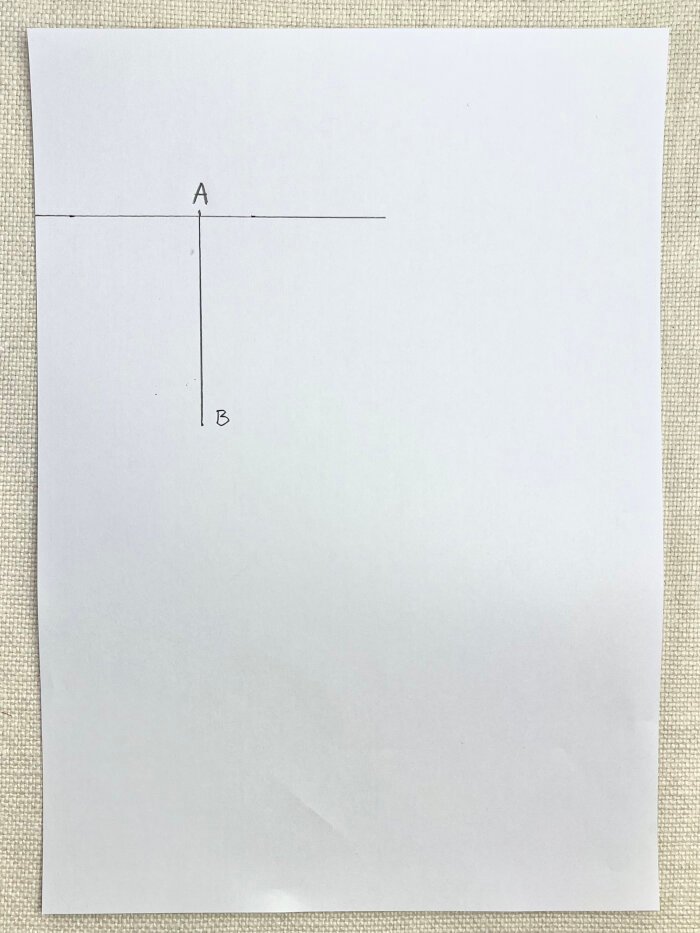 Marking neckline depth on paper for baby drool bib pattern drafting
