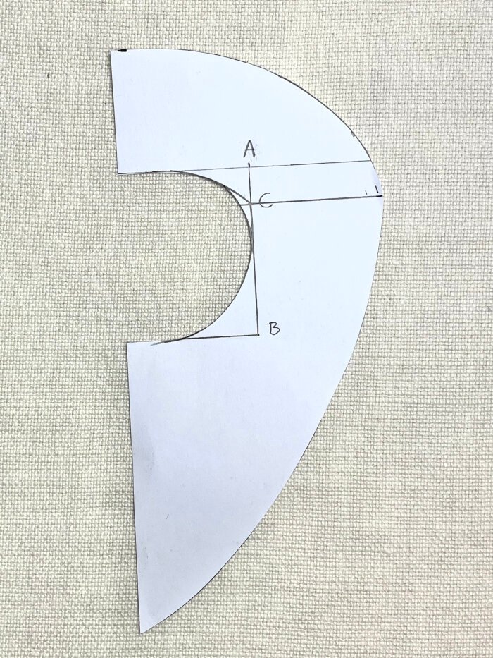 Cutting out drafted baby drool bib pattern from paper for absorbent inner layer