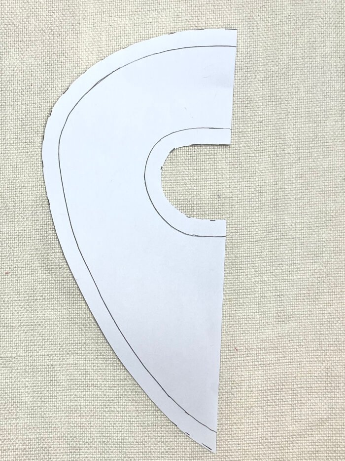 Cutting out drafted baby drool bib pattern from paper