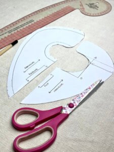 Drafted baby drool bib pattern showing extended shoulder and chest coverage for teething babies