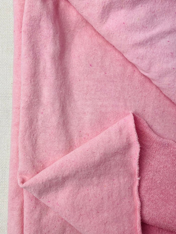 Close-up of dyed hemp fabric showing natural speckling and fibre texture