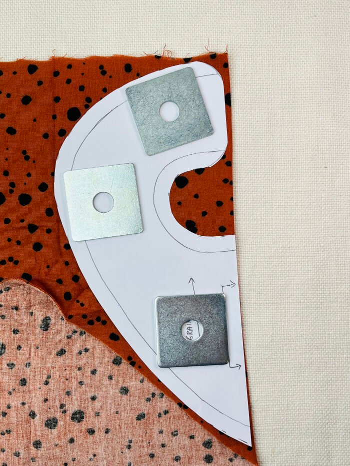 How to Sew a Baby Drool Bib (Easy Step-by-Step Sewing Tutorial) Baby drool bib pattern placed on folded fabric ready for tracing