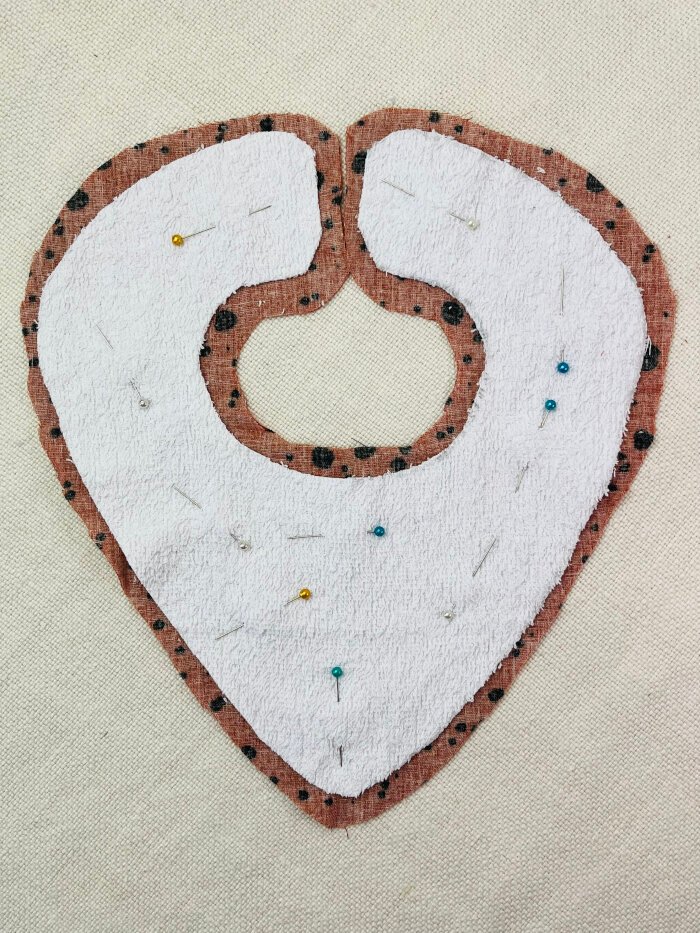 How to Sew a Baby Drool Bib (Easy Step-by-Step Sewing Tutorial) Pinning absorbent middle layer to outer fabric for baby drool bib sewing