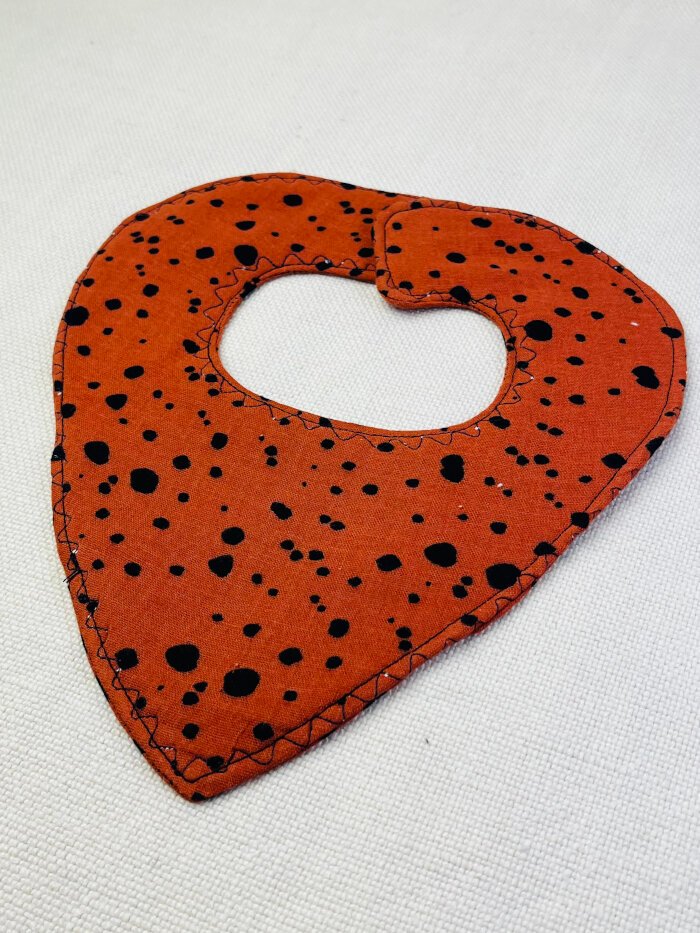 How to Sew a Baby Drool Bib (Easy Step-by-Step Sewing Tutorial) Finished baby drool bib with evenly topstitched edges, prior to adding closure