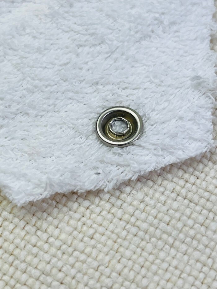 Properly installed metal snap button with smooth finish and no sharp prongs sticking out