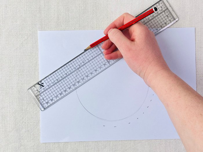 Adding seam allowance to a curved seam on a sewing pattern using a grading ruler and dot-to-dot method