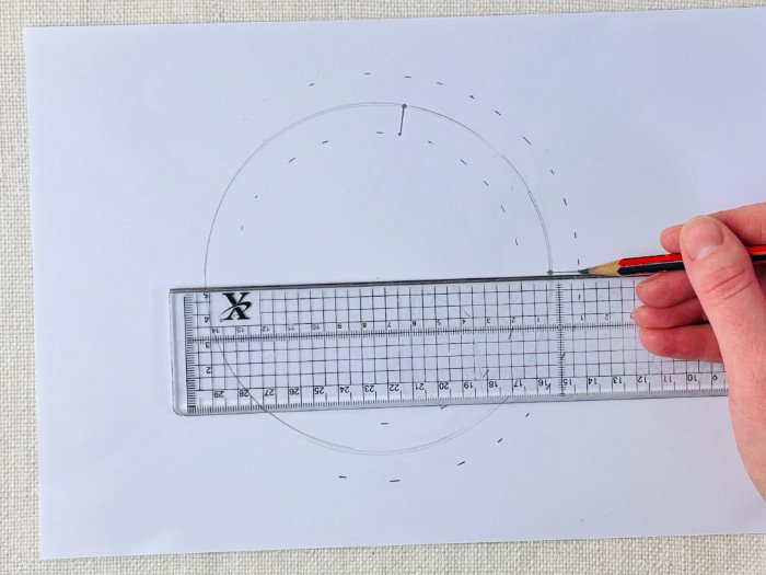 Transferring pattern notches from seam line to seam allowance using a grading ruler on a straight line on a curved line