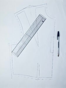 Sewing pattern with seam allowances added on paper, showing outer cutting line and original seam line