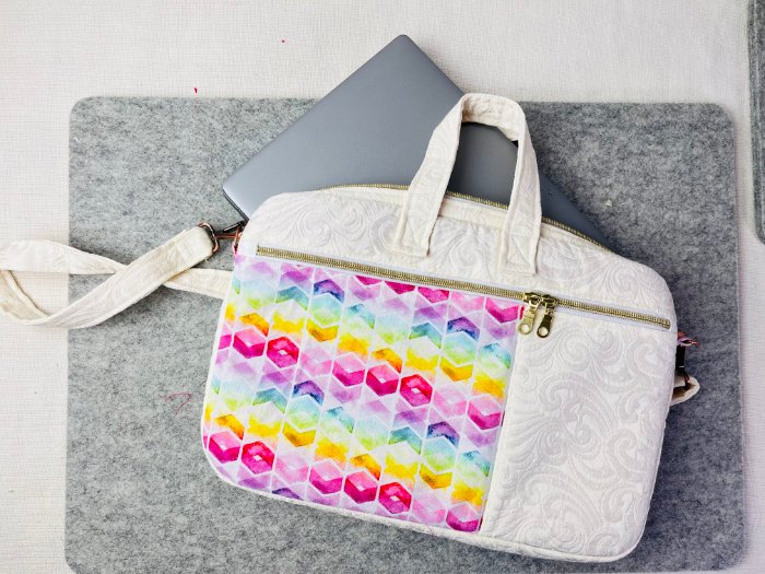 Handmade padded laptop bag with zipper pockets and adjustable shoulder strap shown holding a 14-inch laptop inside lined interior