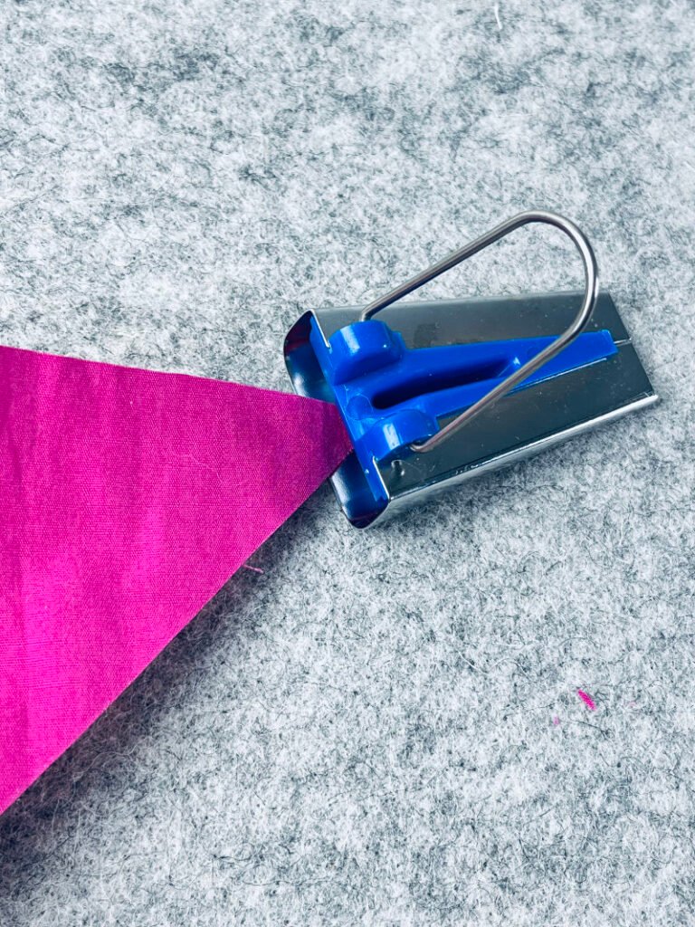 How to Make Bias Binding (Step-by-Step Tutorial for Beginners) Feeding fabric strip through bias tape maker tool to create bias tape.