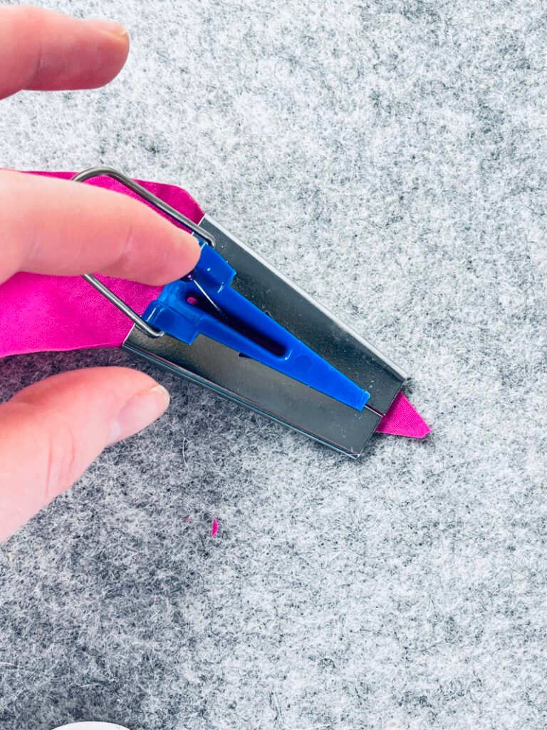 How to Make Bias Binding (Step-by-Step Tutorial for Beginners) Using pin to nudge the bias strip through the bias binding tool