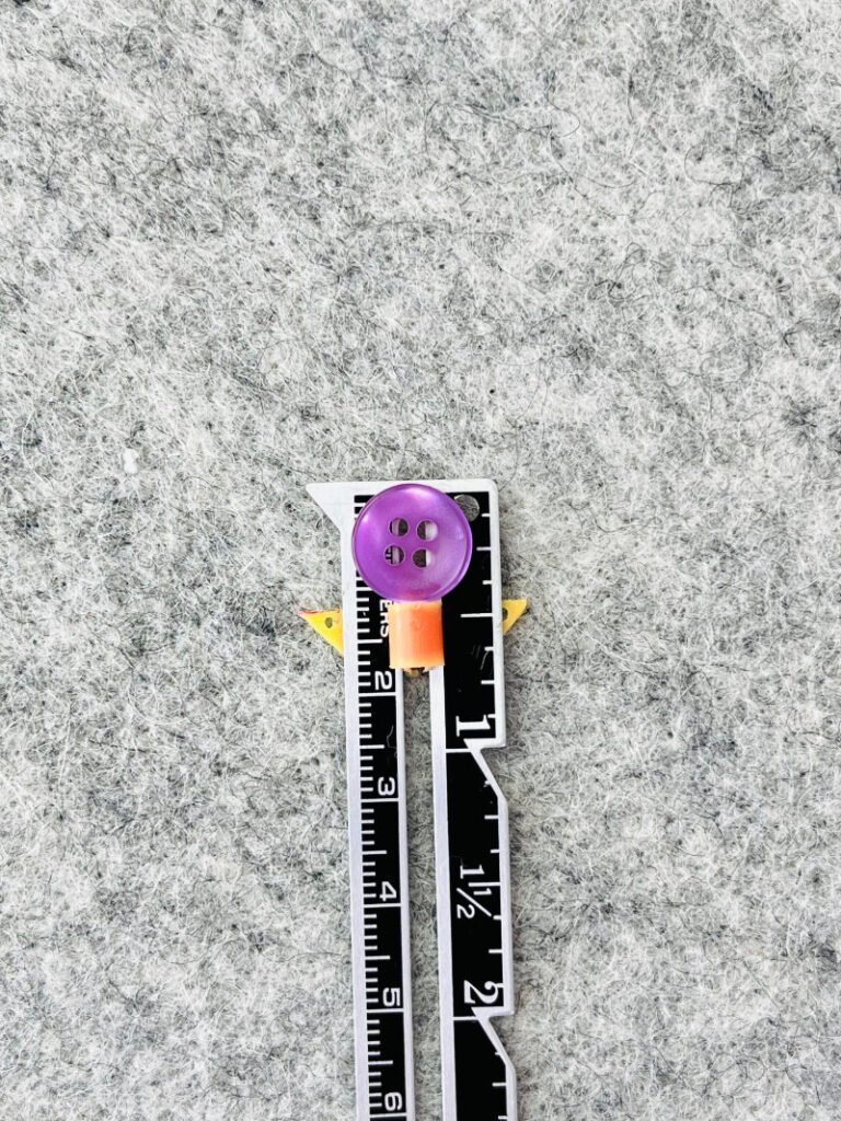 measuring the width of button for buttonhole length with seam gauge