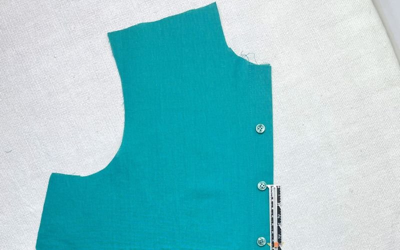 Marking buttonhole placement along button stand using buttons to plan even spacing