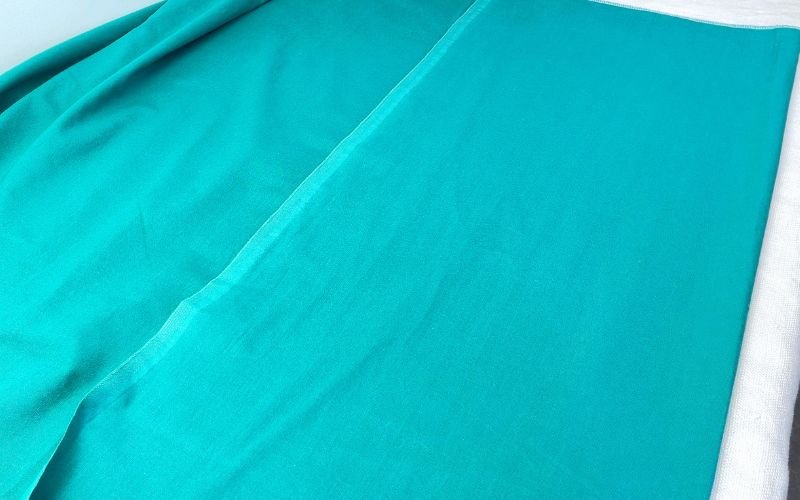 Pressed cotton fabric laid flat on table, smooth and wrinkle-free, ready for accurate shirt sewing