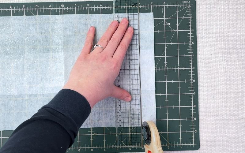 Cutting narrow fusible interfacing strips with rotary cutter and quilting ruler for button stand