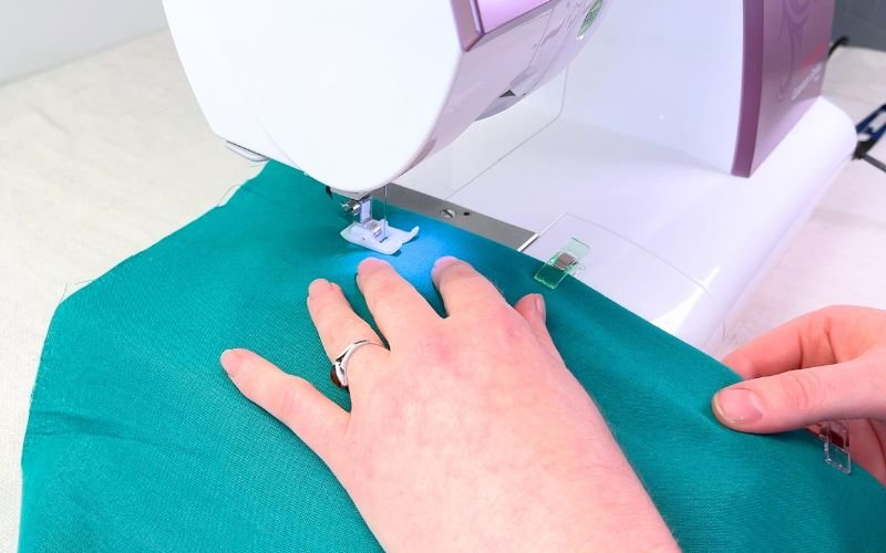 Clipping folded button stand and topstitching close to edge on sewing machine from right side