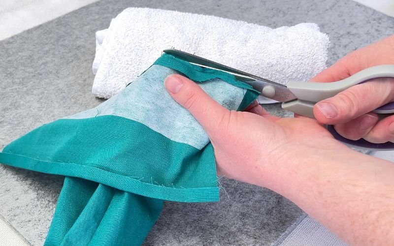 Trimming sleeve cuff seam allowance to reduce bulky seams