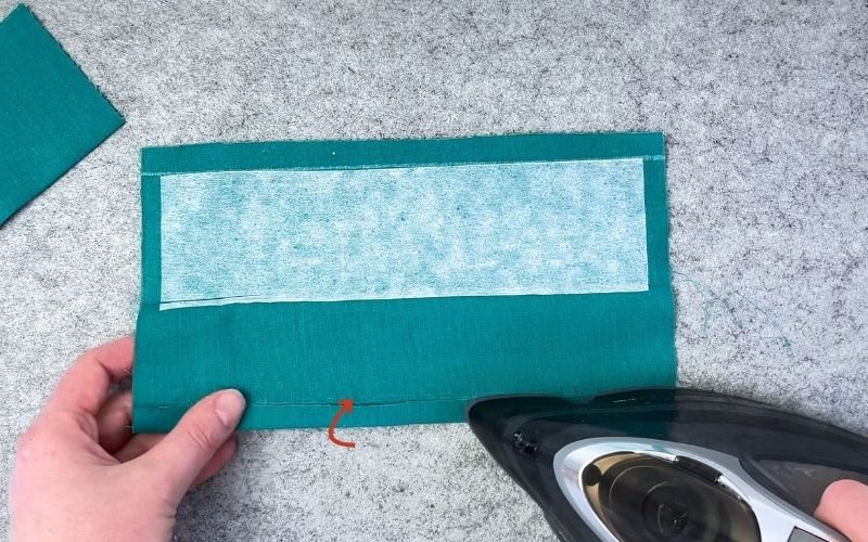 Pressing folded edge on prepared shirt sleeve cuff