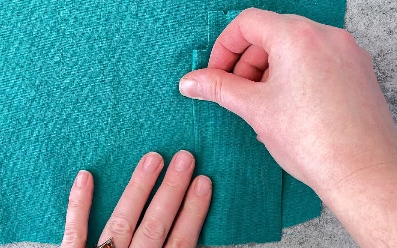 Folding the left side of the seam before turning the sleeve placket to the right side