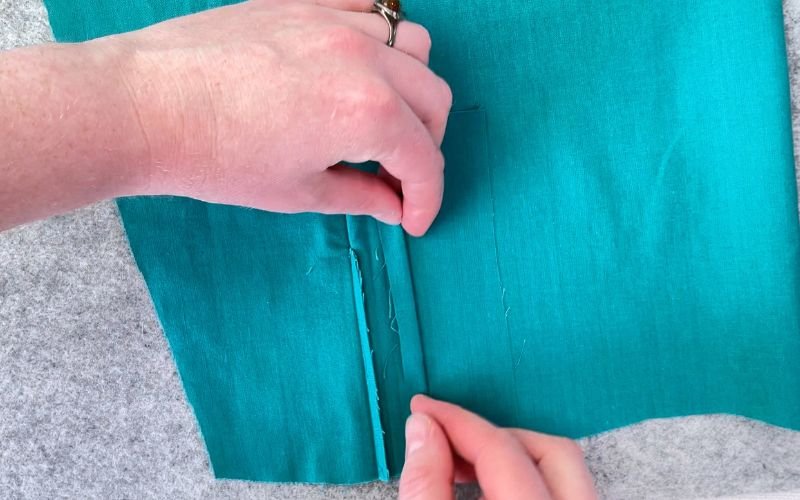 Folding seam allowance on the narrower placket side