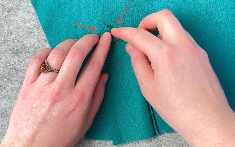 Folding the decorative triangle at the top of the sleeve placket