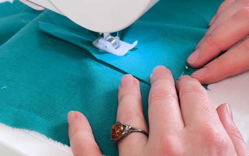 Sewing the side of the upper placket to secure the raw edges